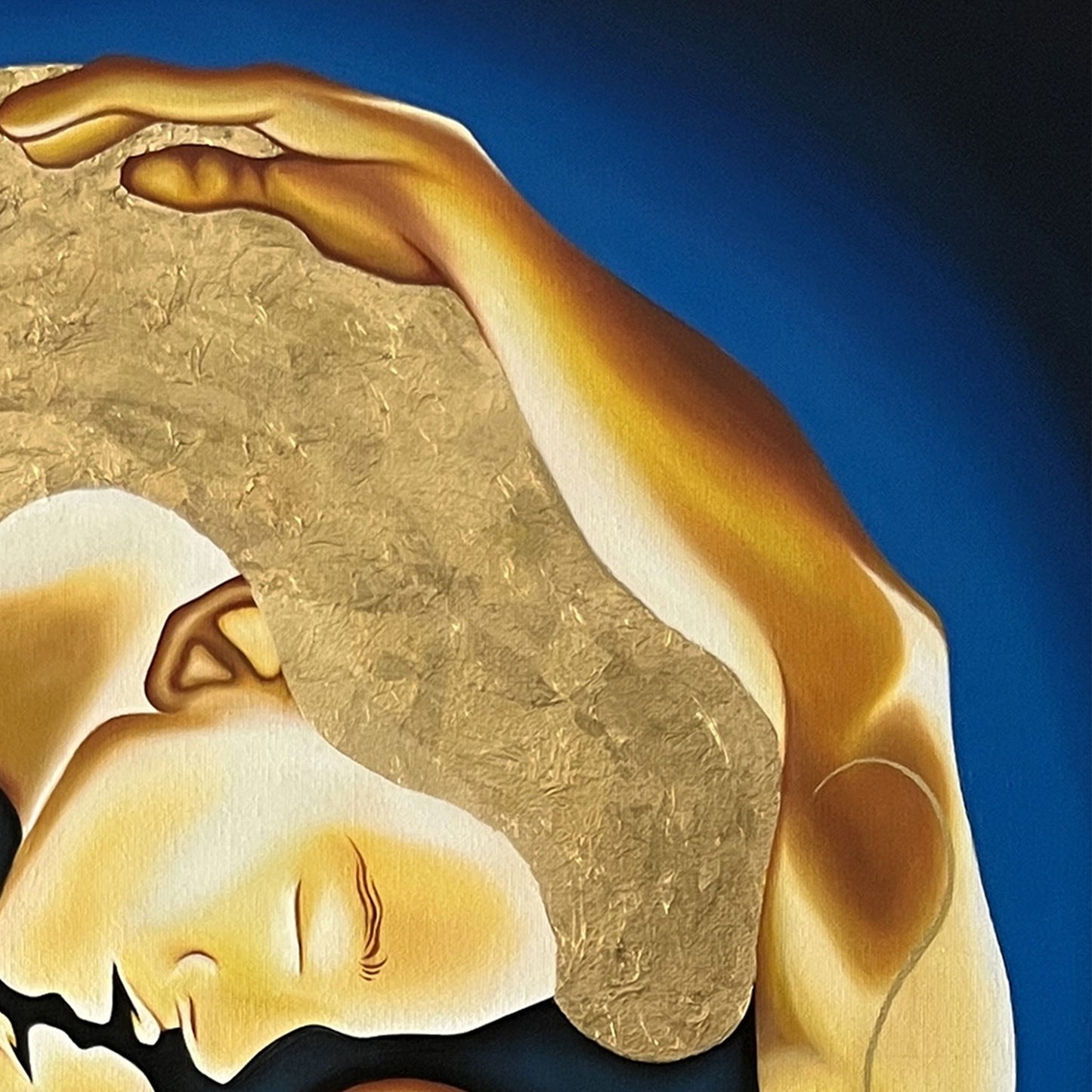 Close up of painting with a gold circular design featuring two figures embracing on a blue background